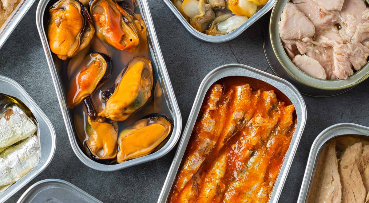 Selection of open Spanish conservas tins with bonito tuna, mussels and anchovies