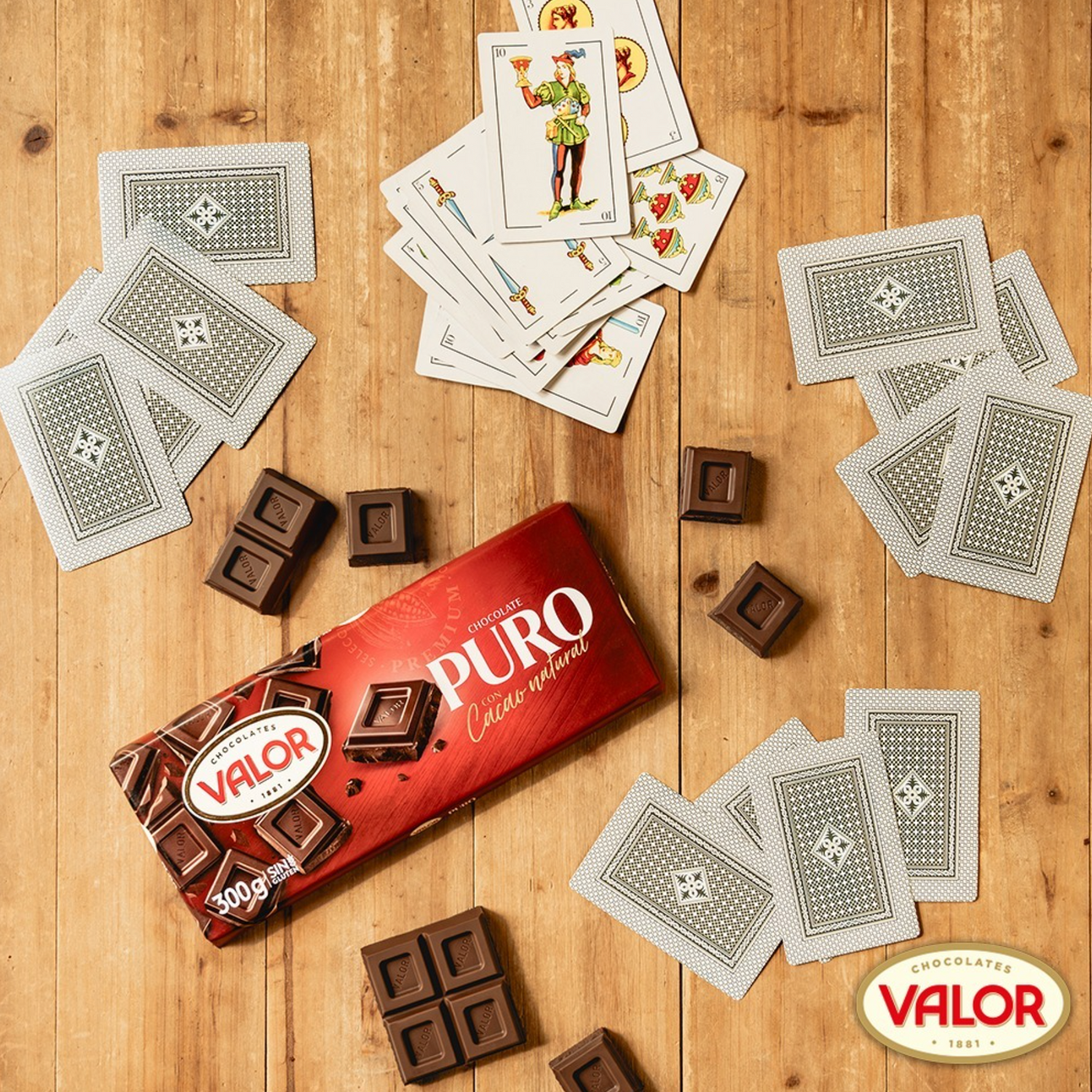 Valor chocolate bars and playing cards on a wooden surface