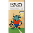 A bar of FOLCS Friendly Chocolate featuring a colorful illustration of a bull soccer player on a field. The packaging is cream and beige with a white top section containing the brand name 'FOLCS' and product details.