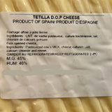 A round wedge of Tetilla D.O.P. Cheese with a white product label showing production details.