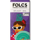 A bar of FOLCS Friendly Chocolate, 82% dark chocolate, featuring a purple wrapper with a colorful illustration of a woman in sunglasses holding a fan.